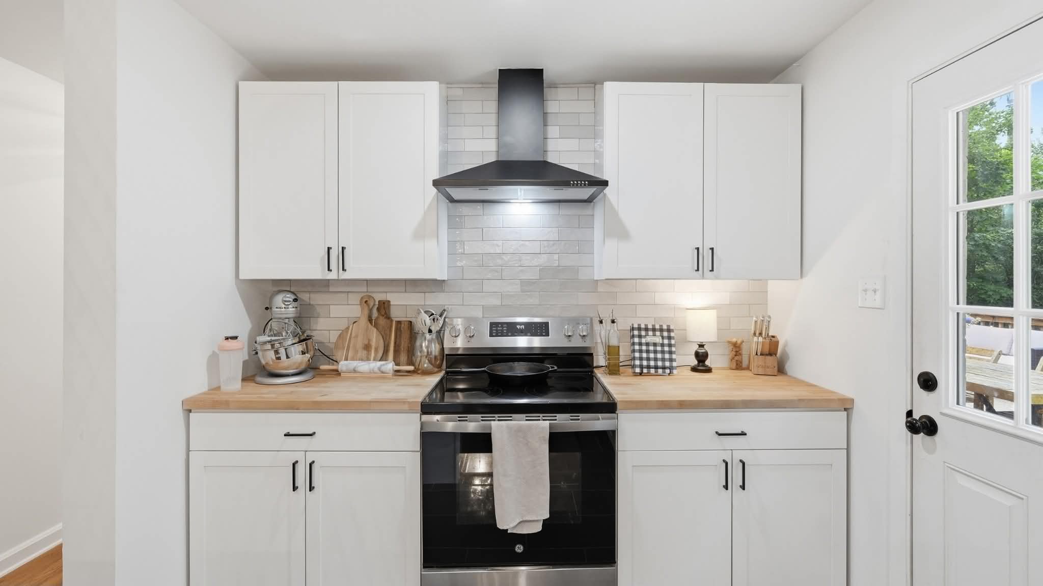 Kitchen with butcher block counters and black range hood